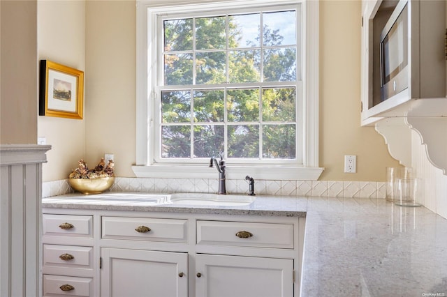 75 Oak Neck Ln, West Islip, NY 11795 - kitchen featuring white cabinets, healthy amount of natural light, and a sink