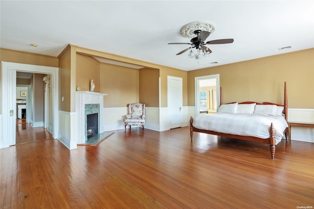 75 Oak Neck Ln, West Islip, NY 11795 - bedroom featuring a high end fireplace, wood finished floors, a wainscoted wall, and ornamental molding