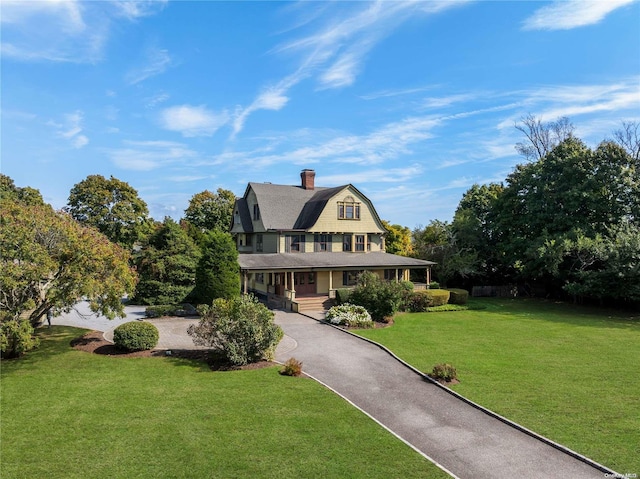 75 Oak Neck Ln, West Islip, NY 11795 - view of front of house with a gambrel roof, a porch, asphalt driveway, a front yard, and a chimney