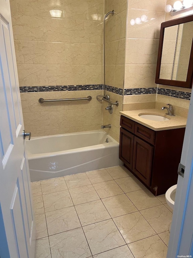 full bathroom featuring toilet, vanity, tile walls, and tiled shower / bath