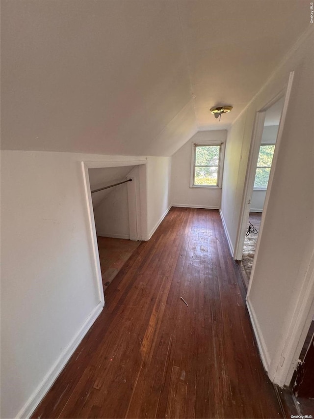 bonus room with dark wood-type flooring and vaulted ceiling