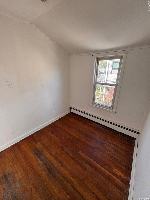 empty room with baseboard heating, dark wood-type flooring, and vaulted ceiling