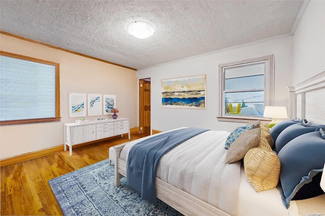 bedroom featuring hardwood / wood-style floors, a textured ceiling, and crown molding