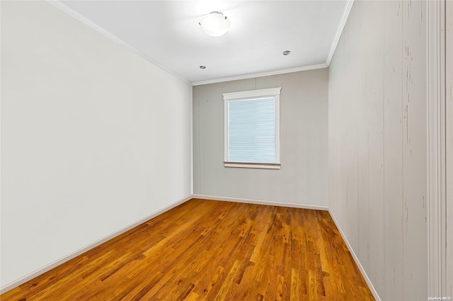 spare room featuring wood-type flooring and ornamental molding