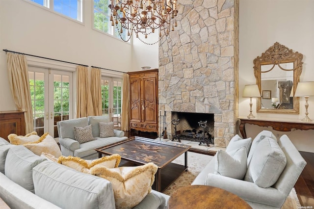 living room featuring a fireplace, french doors, a towering ceiling, and plenty of natural light