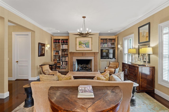 living room featuring a chandelier, dark hardwood / wood-style floors, a fireplace, and crown molding