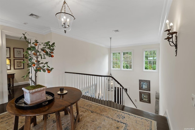 interior space with crown molding, an inviting chandelier, and hardwood / wood-style flooring