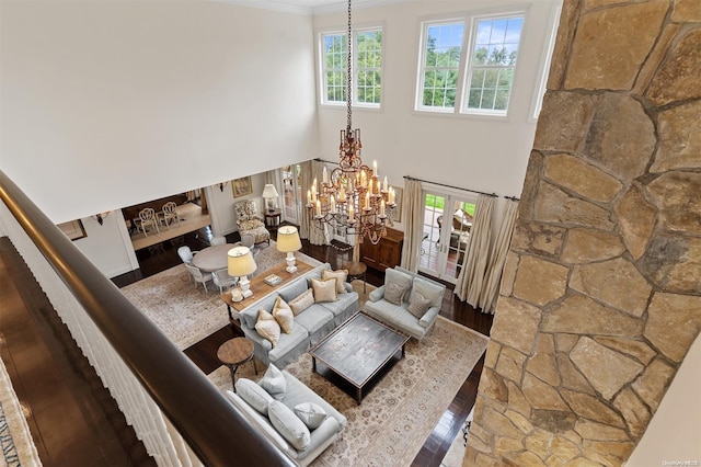 living room featuring hardwood / wood-style floors, crown molding, a wealth of natural light, and a chandelier