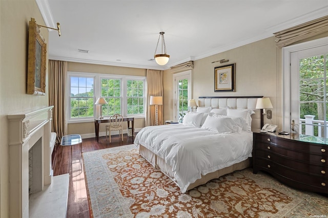 bedroom with crown molding, light hardwood / wood-style flooring, and multiple windows