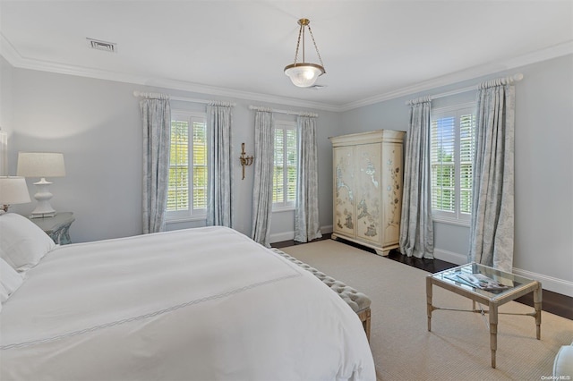 bedroom with wood-type flooring, ornamental molding, and multiple windows