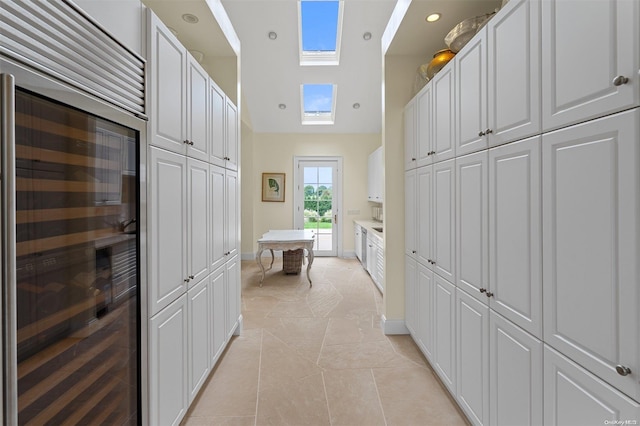 interior space featuring tile patterned floors, a high ceiling, and wine cooler