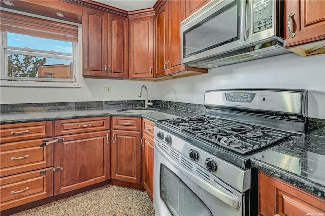 kitchen featuring sink, dark stone counters, and appliances with stainless steel finishes