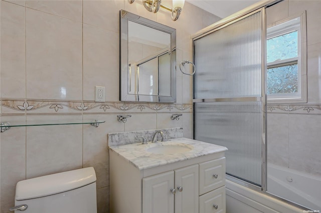 full bathroom featuring vanity, enclosed tub / shower combo, tile walls, and toilet