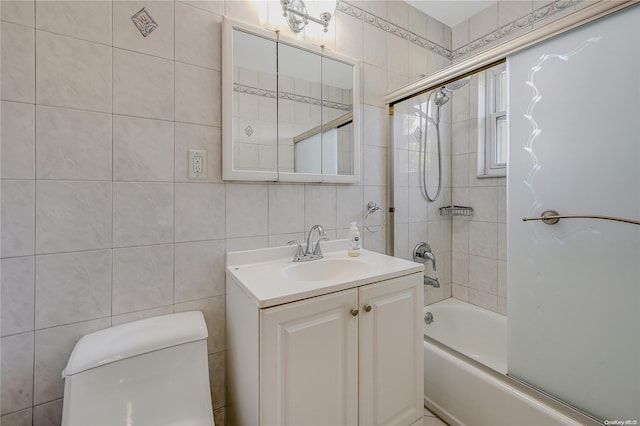 full bathroom featuring vanity, enclosed tub / shower combo, tile walls, and toilet