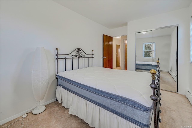 carpeted bedroom featuring a closet and a baseboard heating unit