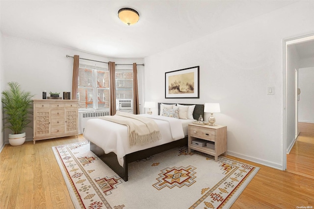 bedroom featuring wood-type flooring and radiator heating unit