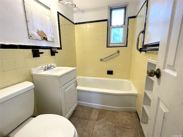 bathroom featuring tile patterned floors, toilet, tile walls, tub / shower combination, and vanity