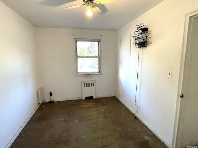 spare room with radiator, a ceiling fan, and concrete flooring