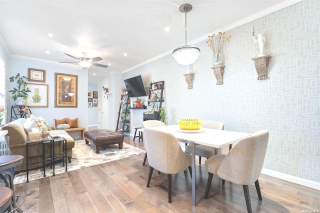 dining space with ceiling fan, hardwood / wood-style floors, and ornamental molding