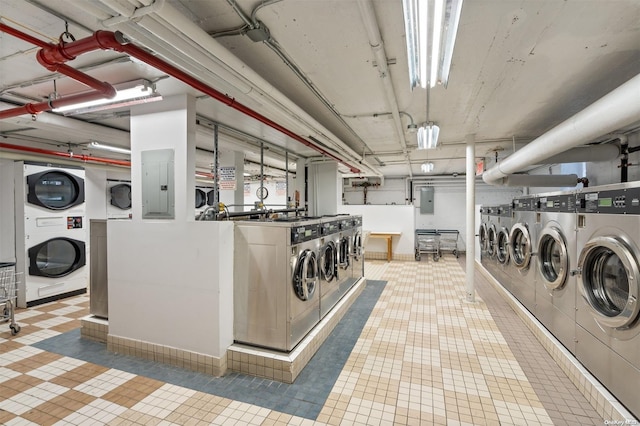 laundry room with electric panel, washer and clothes dryer, and stacked washer / drying machine