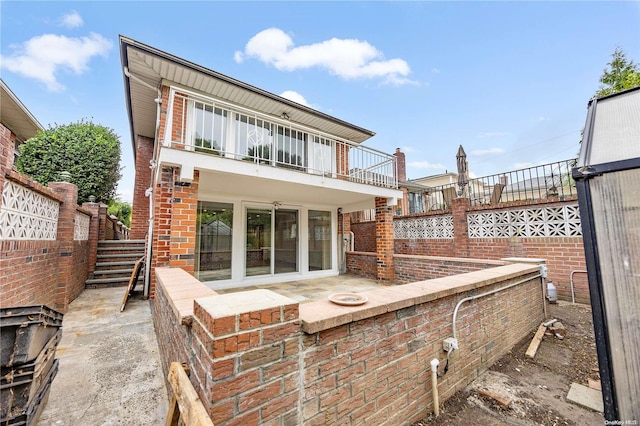 back of property with a balcony and a patio