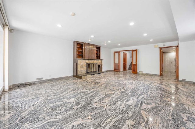 unfurnished living room featuring a stone fireplace