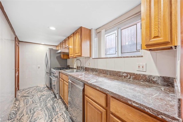 kitchen with light stone countertops, sink, and appliances with stainless steel finishes