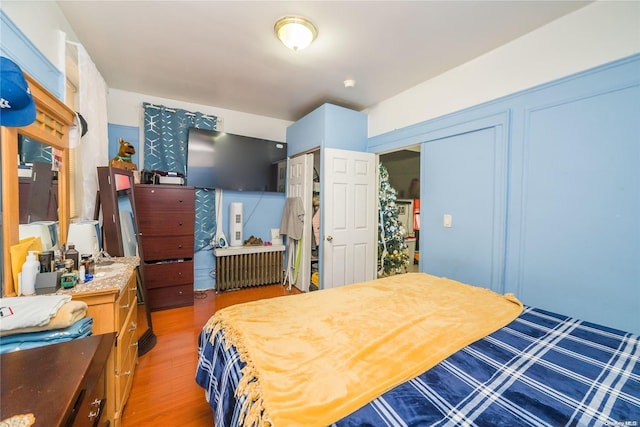 bedroom featuring hardwood / wood-style floors, a closet, and radiator