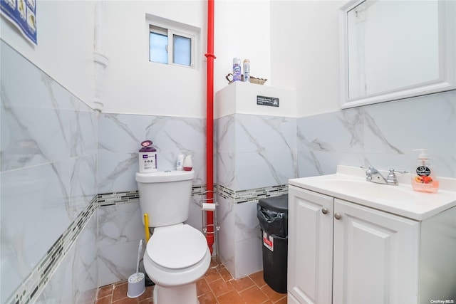 bathroom with vanity, toilet, and tile walls