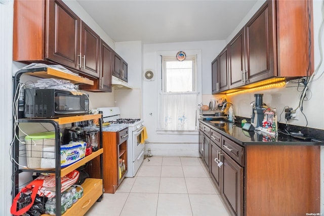 kitchen featuring white range with gas cooktop, sink, and light tile patterned flooring