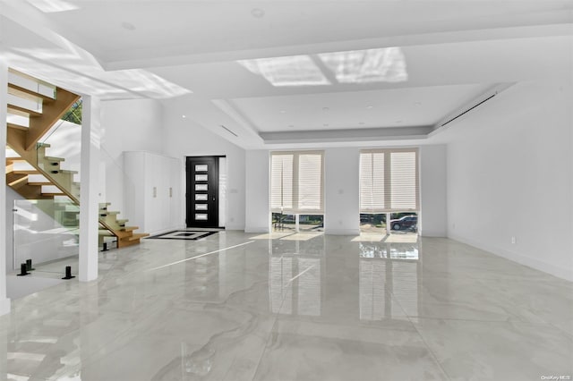 unfurnished living room with a tray ceiling