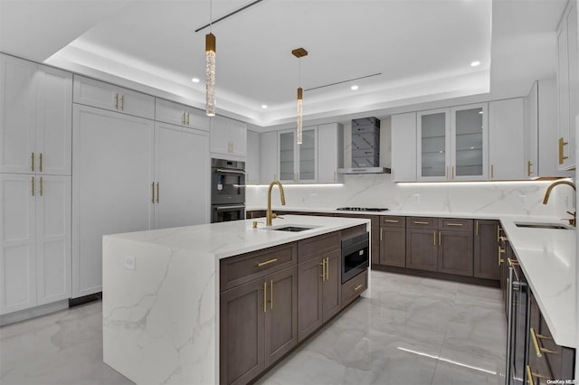 kitchen with a raised ceiling, hanging light fixtures, and sink