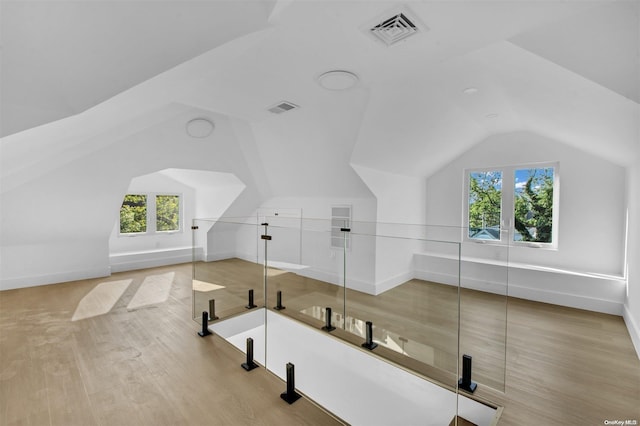 additional living space with lofted ceiling and light wood-type flooring