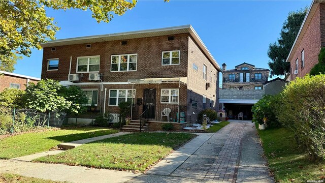 view of front facade featuring driveway, a front yard, and brick siding