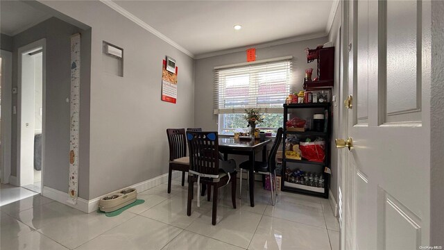 dining room with light tile patterned floors, baseboards, and ornamental molding