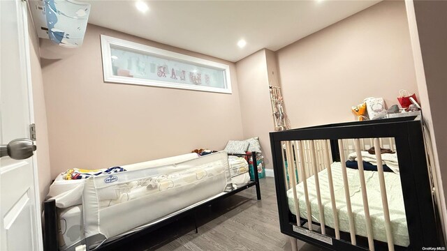 bedroom featuring baseboards, wood finished floors, and recessed lighting