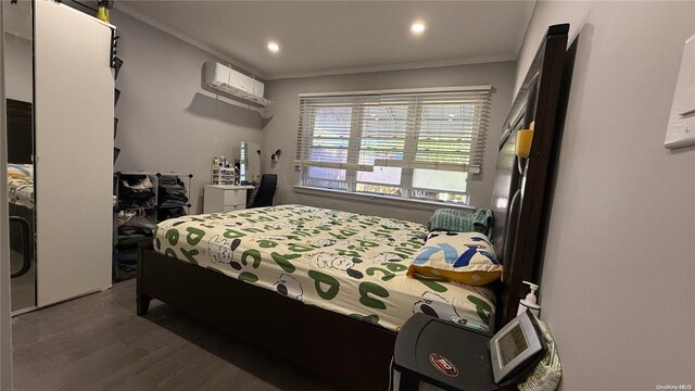 bedroom featuring a wall unit AC, recessed lighting, crown molding, and wood finished floors