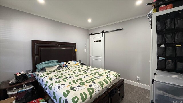 bedroom with a barn door, crown molding, baseboards, and dark wood-style flooring