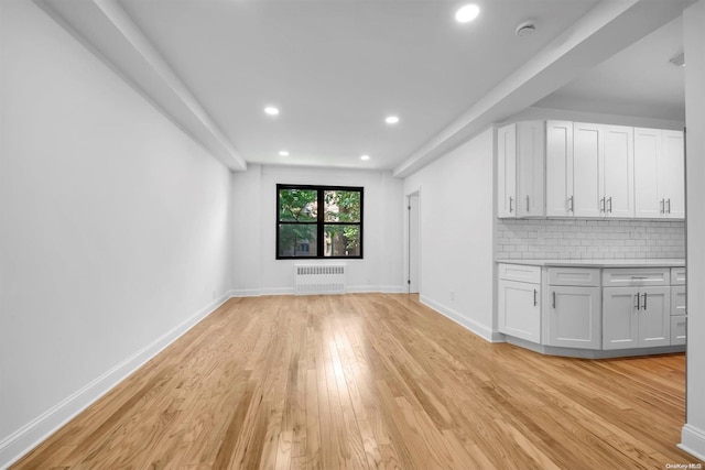 unfurnished living room with light wood-type flooring and radiator