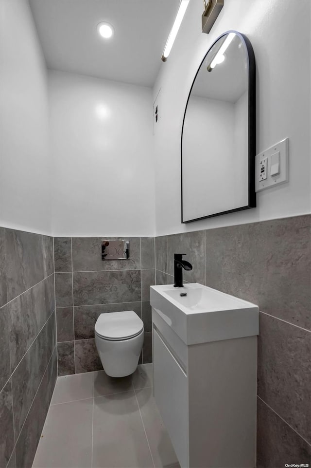 bathroom with tile patterned floors, vanity, toilet, and tile walls