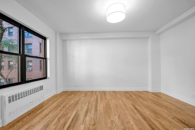 spare room with radiator and light hardwood / wood-style flooring