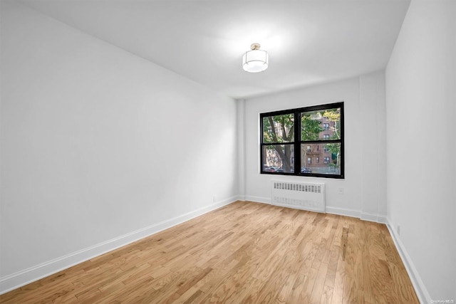 unfurnished room with light wood-type flooring and radiator