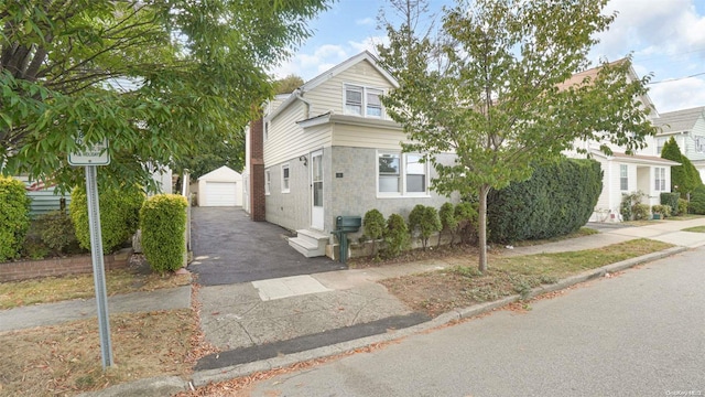 view of front of home featuring a garage and an outbuilding