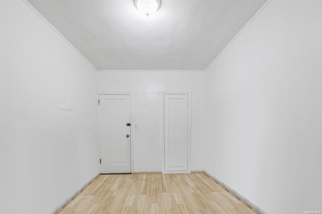 empty room featuring light hardwood / wood-style floors and crown molding