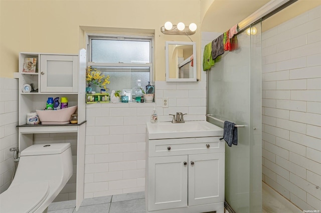 bathroom featuring tile patterned flooring, vanity, toilet, and tile walls