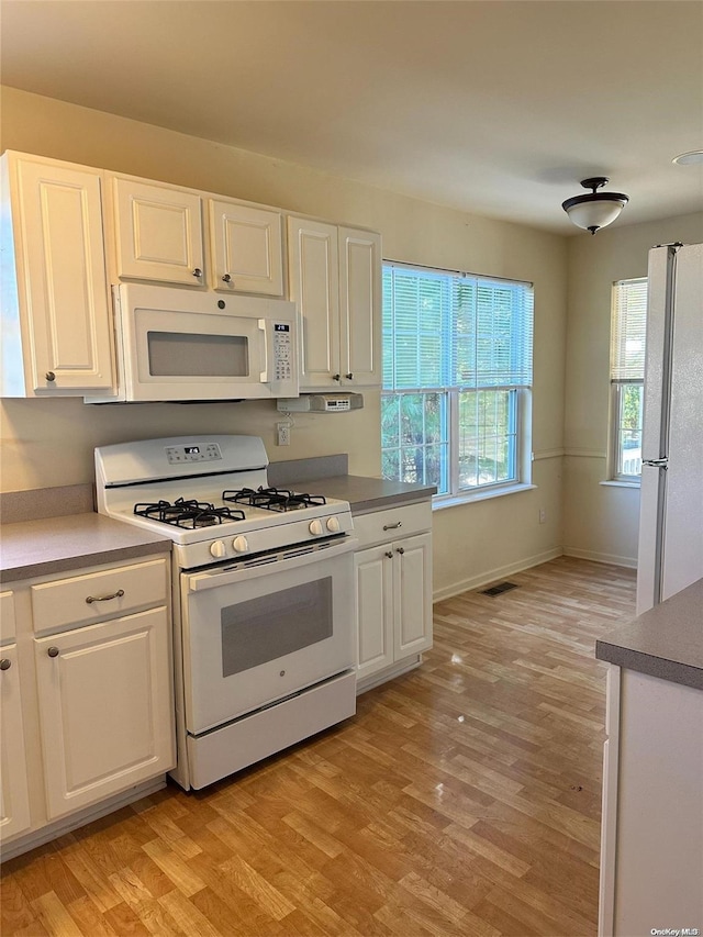 kitchen featuring white cabinetry, white appliances, and light hardwood / wood-style flooring