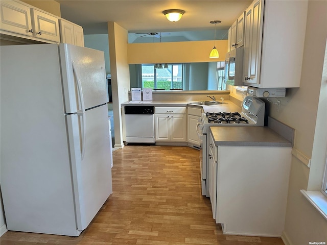 kitchen with sink, white appliances, white cabinets, decorative light fixtures, and light wood-type flooring