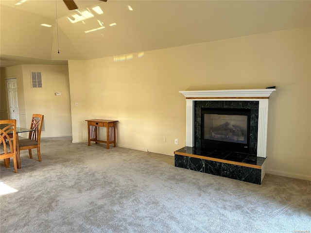 unfurnished living room with a high end fireplace, lofted ceiling, and carpet floors