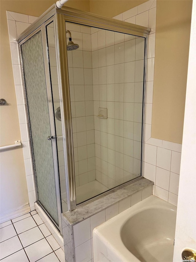 bathroom featuring tile patterned floors and shower with separate bathtub