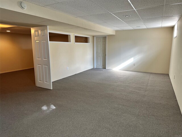 basement with a paneled ceiling and carpet floors